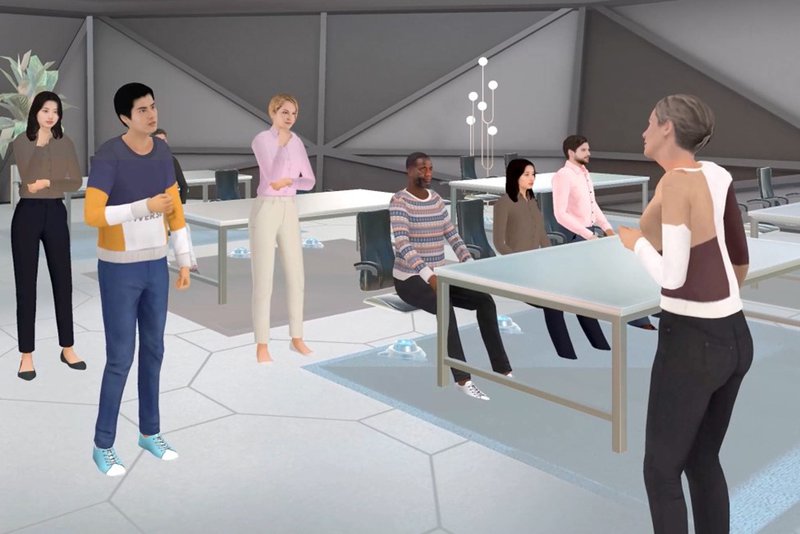 A virtual reality scene depicting a classroom with multiple user avatars standing and sitting around desks..jpg