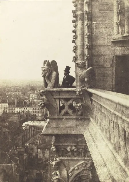 The Le Stryge gargoyle next to an old gentleman in a top hat standing in Notre-Dame Cathedral