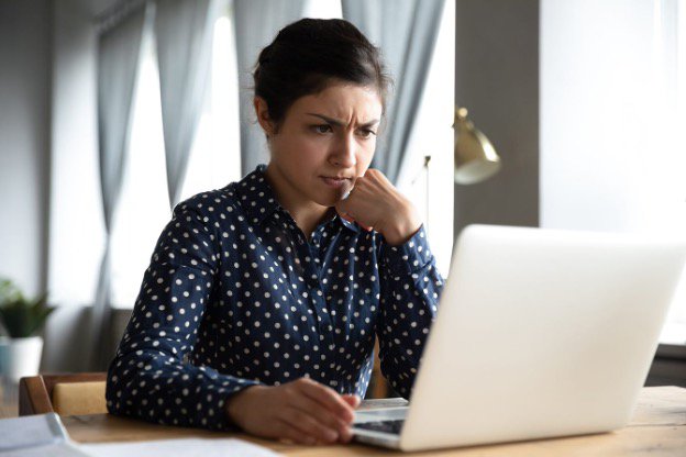Person looking at a laptop computer with a hesitant expression.jpg